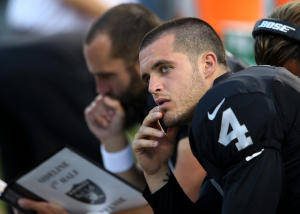Oakland Raiders Derek Carr (4) watches the big screen from the sideline in the first quarter of their preseason NFL game against the Detroit Lions at O.co Coliseum in Oakland, Calif., on Friday, Aug. 15, 2014. (Anda Chu/Bay Area News Group)